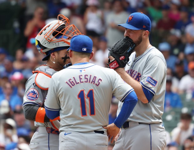 Mets starting pitcher Tylor Megill, right, takes a meeting on the mound in the first inning against the Cubs at Wrigley Field on June 22, 2024, in Chicago. Megill gave up five runs in the first inning. (John J. Kim/Chicago Tribune)