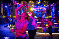 Dancers under colorful lights at night at the Lincoln Center "Summer For the City" festival