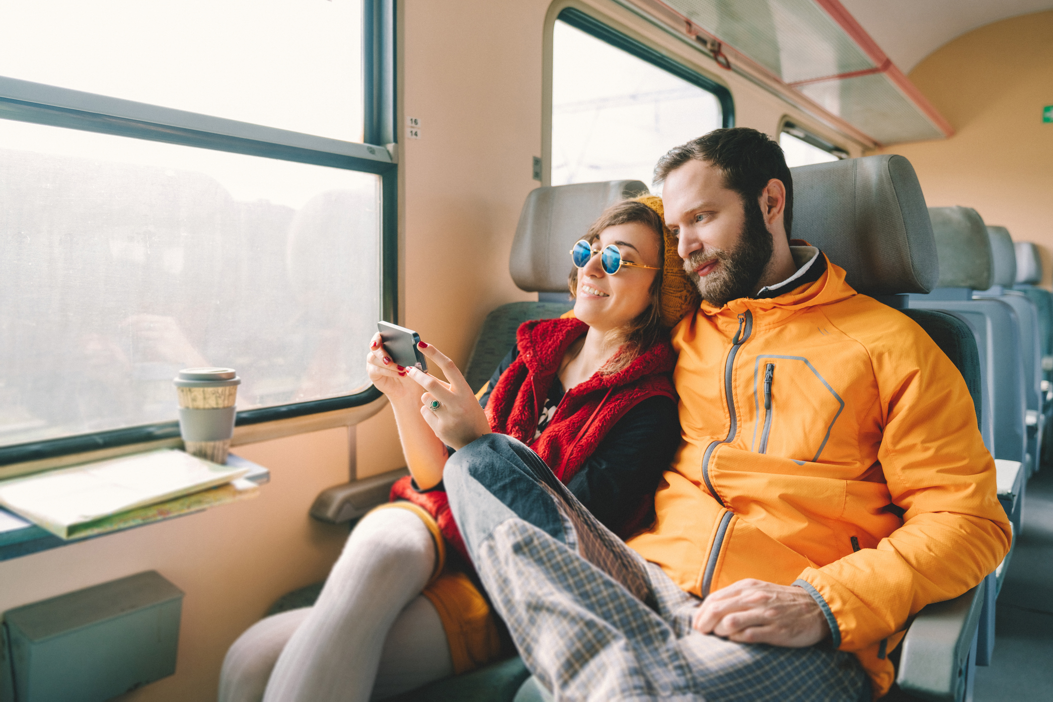 a couple on a train watching a video on a phone