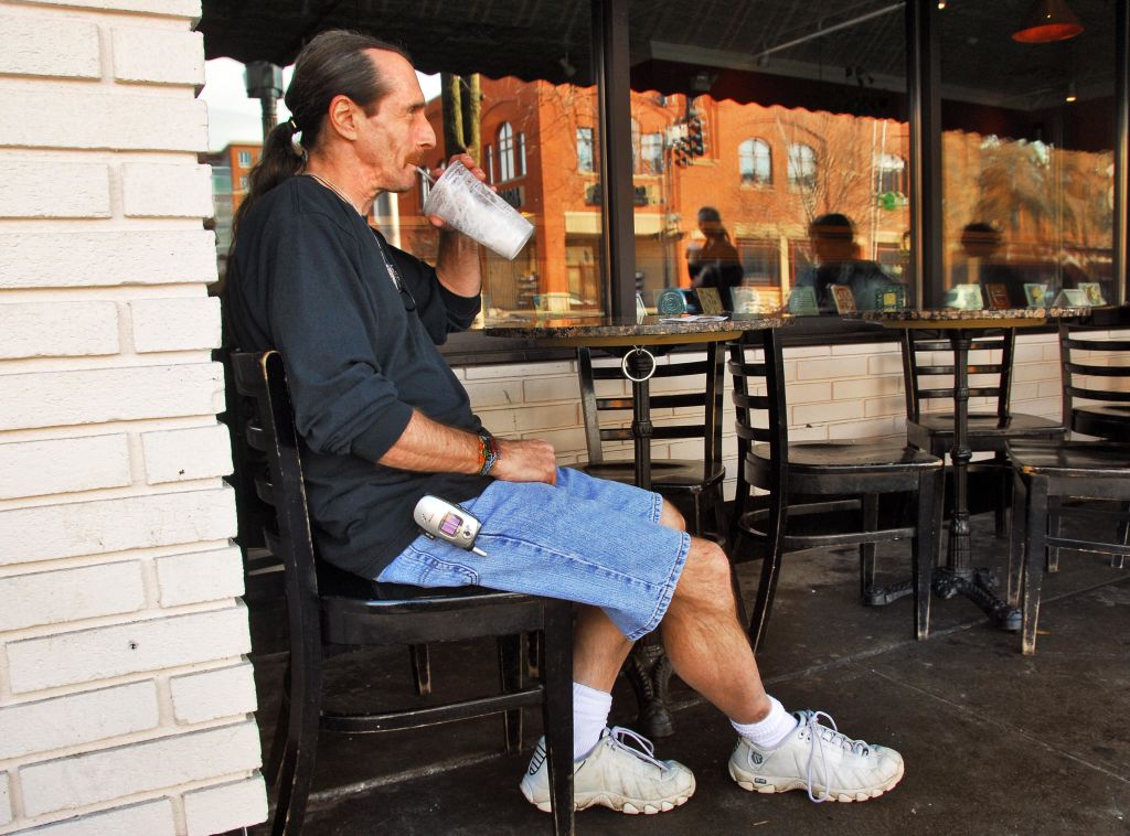 a dude with long denim shorts and a ponytail, chilling