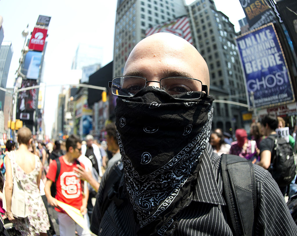 A man wears a black bandana over his face during a protest in 2012.