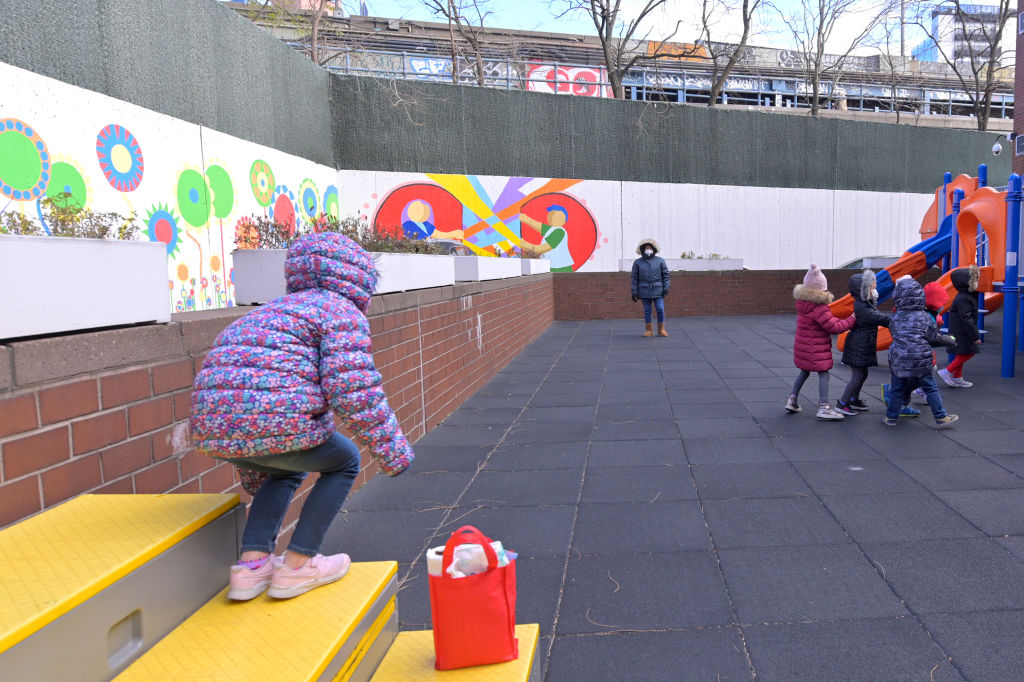 Kids in jackets play outside during recess.