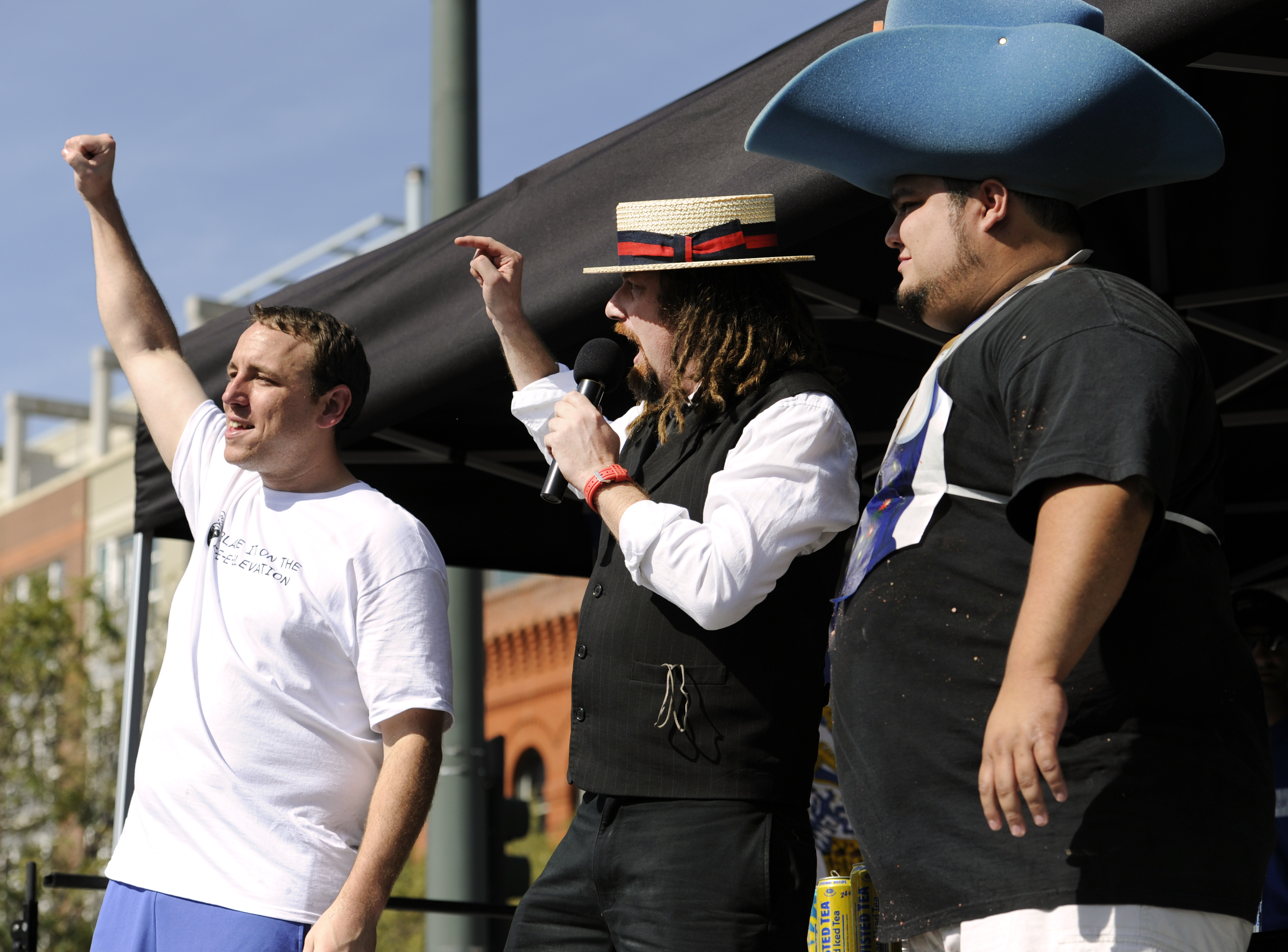 Crazy Legs Conti, center, announces the winner of the contest, Joey "Jaws" Chestnut, left, after eating 38 sausages at the inaugural Continental Sausage Eating Contest hosted by Oktoberfest Denver.