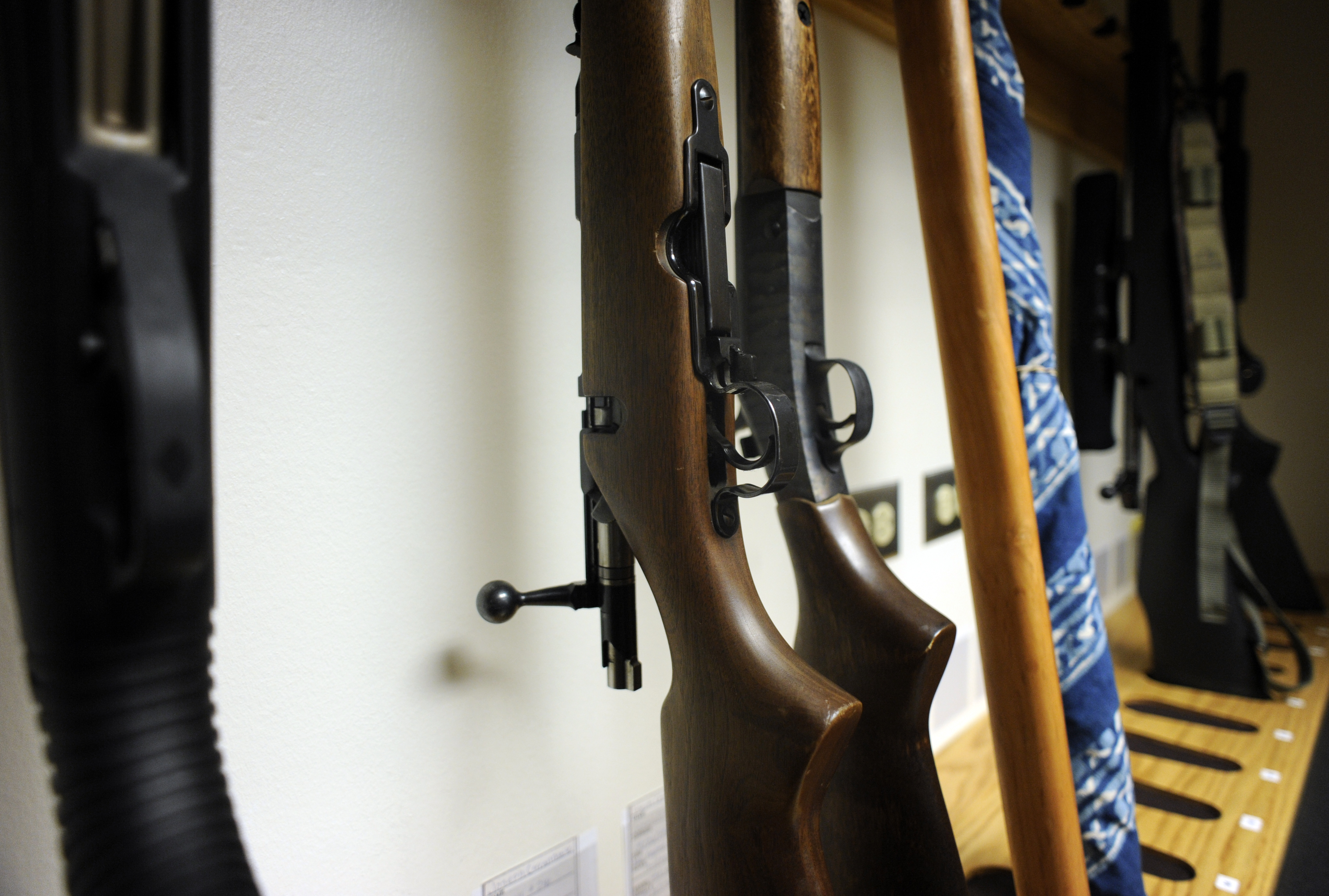 A stock image of shotguns in storage.