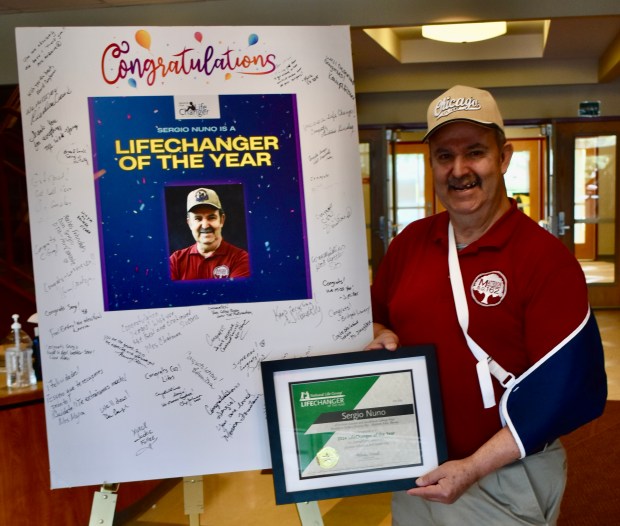 Sergio Nuno, a custodian at Matteson School District 162 schools, received a giant card signed by many well wishers after he had to miss an assembly celebrating him being named one of 17 recipients nationwide of the LifeChanger Award.(Steve Metsch/Daily Southtown)