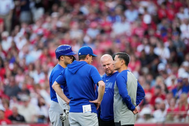 Cubs manager Craig Counsell speaks with right fielder Seiya Suzuki during the fifth inning against the Reds on June 7, 2024, in Cincinnati. (Jeff Dean/Getty)