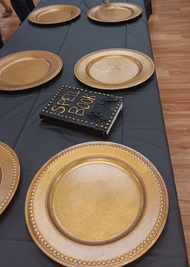 The dining table in "The Great Hall," with a spell book nearby. The finale in the hall ended Antioch's Wizard Weekend Day for visitors. (Gregory Harutunian/For the Lake County News-Sun)