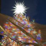 Rockefeller Center Christmas tree captured through the gold flags around the ice rink